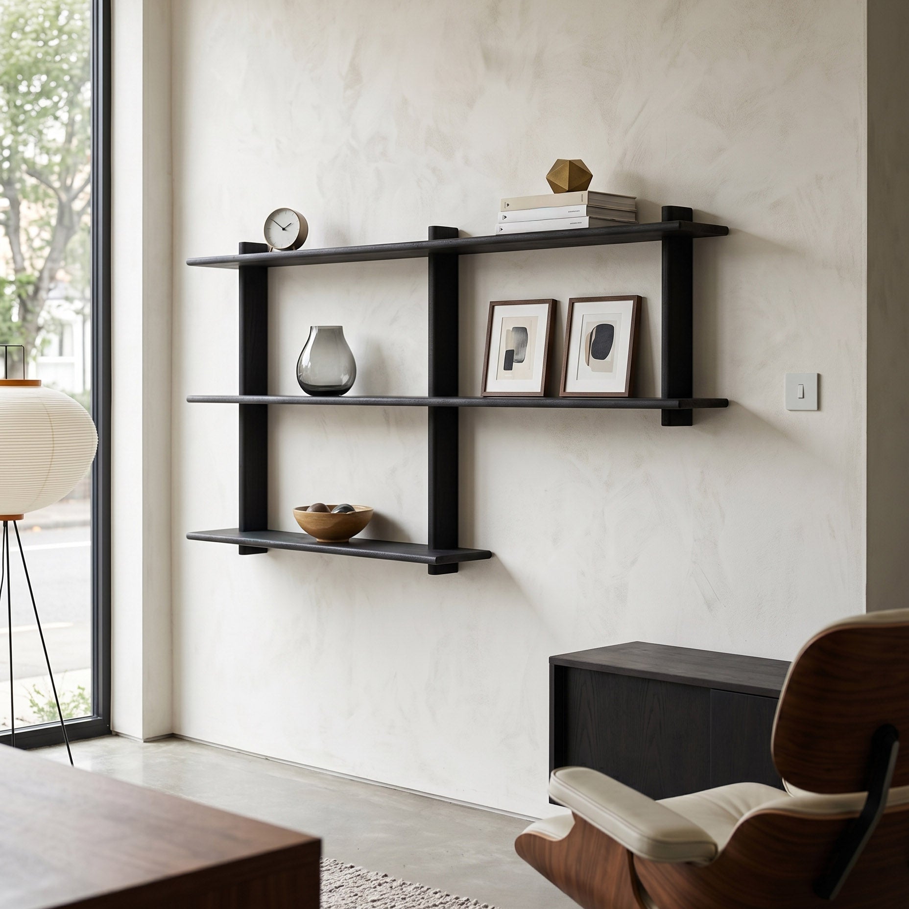 Black wall shelf with decorative items in a modern room setting.